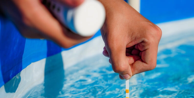 Technician testing pool water during professional maintenance by Commercial Pool Kings.