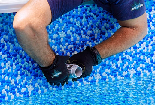 Technician adjusting pool plumbing as part of a customized service plan by Commercial Pool Kings.