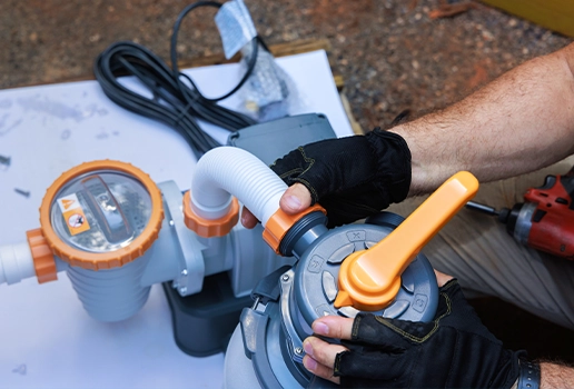 Technician adjusting a commercial pool filter during equipment inspection by Commercial Pool Kings.