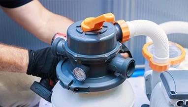 Technician adjusting a commercial pool filter during equipment inspection by Commercial Pool Kings.